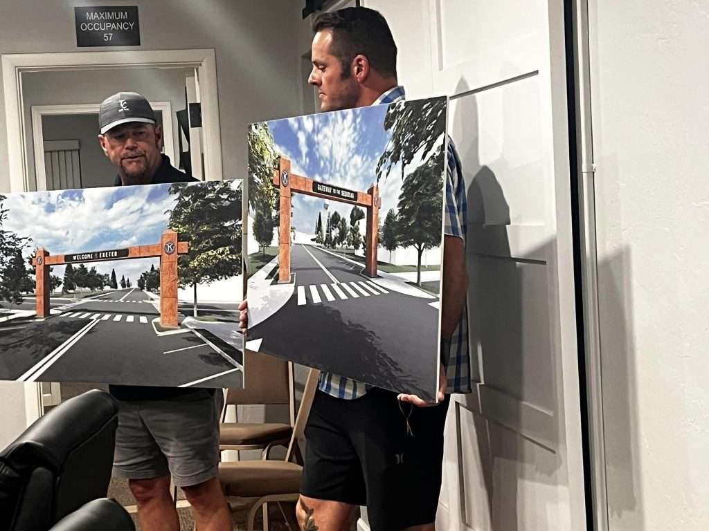 Two Kiwanis members holding design renderings for an Exeter gateway project